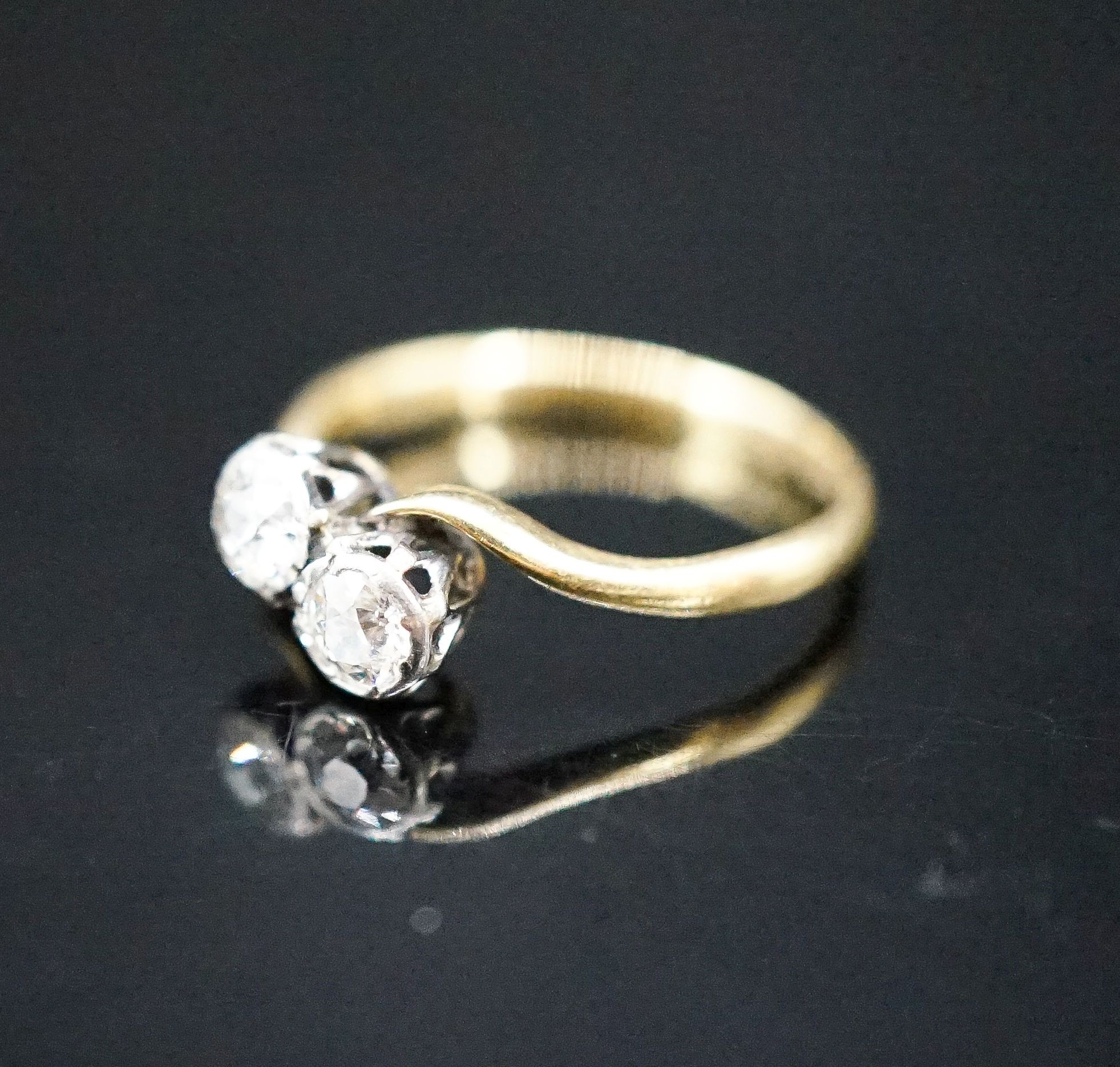 An 18ct & plat, two stone diamond crossover ring, size J, gross weight 1.8 grams.